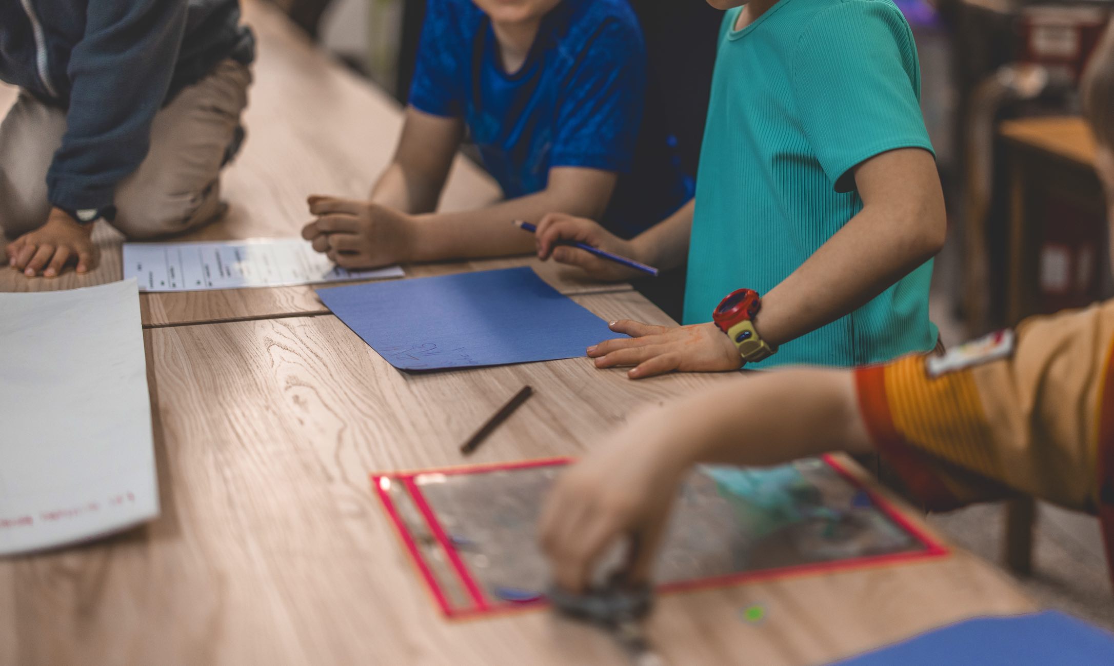 Des enfants collaborent autour d'une table pendant un Club.