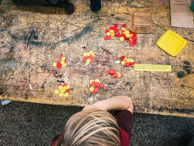 Un enfant manipule des jetons pour rendre les nombres et les opérations visibles